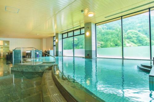 a large indoor swimming pool in a building at Hotel Hikyounoyu in Itchū