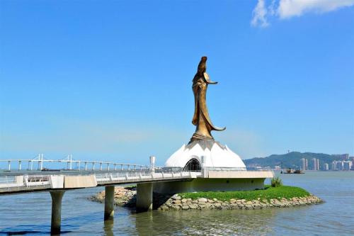 een brug over het water met een standbeeld erop bij L'Arc Hotel Macau in Macau
