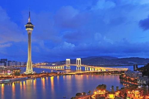Blick auf eine Stadt mit einer Brücke und einem Fluss in der Unterkunft L'Arc Hotel Macau in Macau