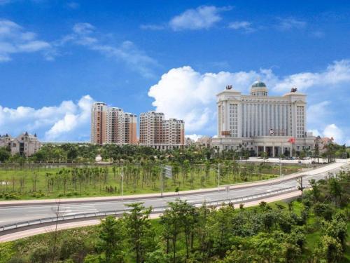 a highway in front of a city with tall buildings at Auspicious Hotel in Zhongshan