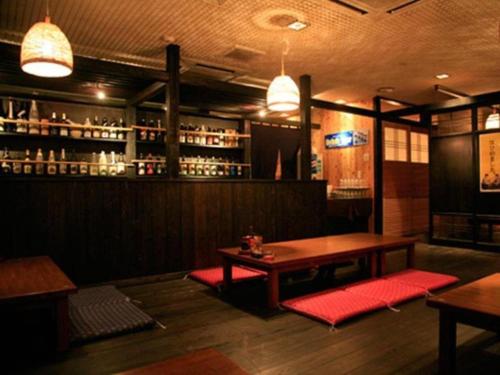 Miyakonojo Sun Plaza Hotel في مياكونوجو: بار مع طاولة وكراسي حمراء في الغرفة