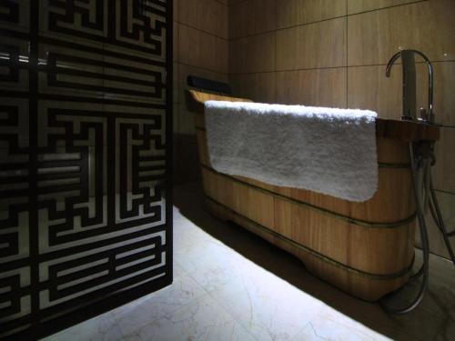ein Badezimmer mit einer Badewanne und einem weißen Handtuch in der Unterkunft Fuzhou Chuanjie Hotspring and Golf Club Hotel in Guling