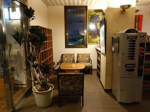 een kamer met een keuken met een tafel en een koelkast bij Personal Hotel You in Takeo