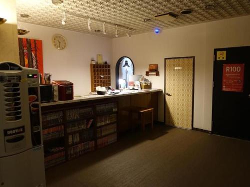 a room with a library with a counter and a door at Personal Hotel You in Takeo