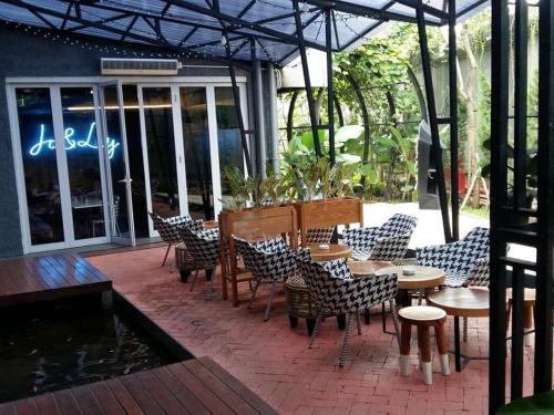 une terrasse avec des chaises et des tables devant un restaurant dans l'établissement Couleur Hotel Cengkareng, à Jakarta