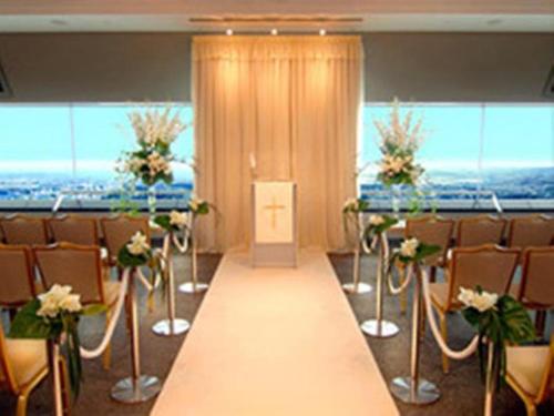 een kamer met tafels en stoelen en een lange gang bij Miyakonojo Royal Hotel in Miyakonojo