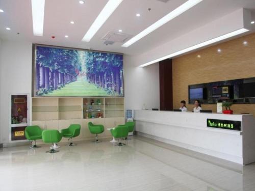 a waiting room with green chairs and a large screen at Vatica Lianyungang Haizhou Xinkong South Road Zhongyin Mingdu Hotel in Yuhang