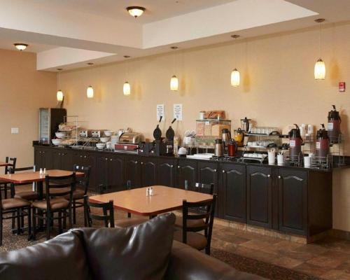 um restaurante com duas mesas e um balcão com um bar em Comfort Inn & Suites em Virden
