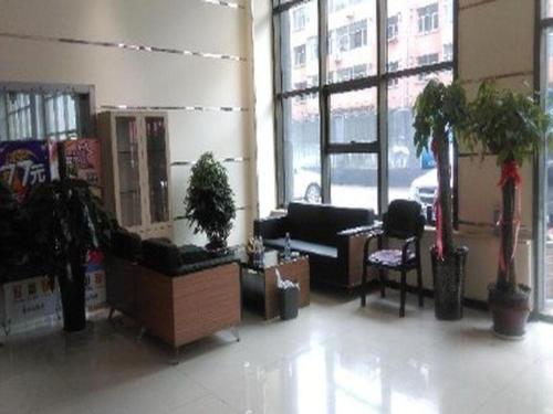 une chambre avec mobilier et plantes dans un bâtiment dans l'établissement 7 Days Inn Wuhai Wanda Plaza, à Wuhai