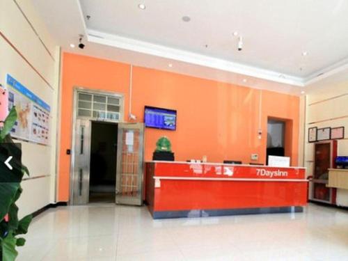 un hall avec un mur orange dans un hôpital dans l'établissement 7 Days Inn Wuhai Wanda Plaza, à Wuhai