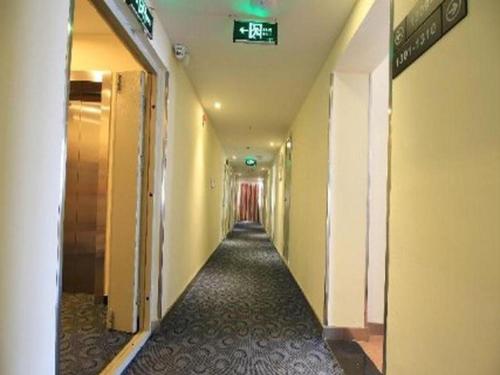 un long couloir avec un panneau au plafond d'un bâtiment dans l'établissement 7 Days Inn Wuhai Wanda Plaza, à Wuhai