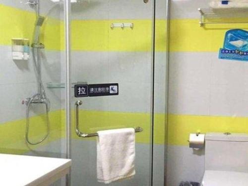 La salle de bains est pourvue d'une douche avec une porte en verre. dans l'établissement 7 Days Inn Wuhai Wanda Plaza, à Wuhai