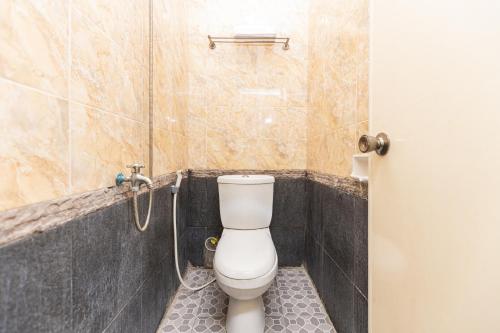 a bathroom with a toilet and a shower at SPOT ON 1990 Pondok Ripuji in Makassar