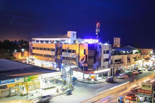 Una ciudad de noche con tráfico delante de un edificio en Anchor Hotel en General Santos