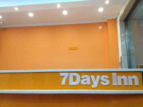 an orange wall with the zdays inn sign on it at 7 Days Inn Beijing South Railway Station in Beijing