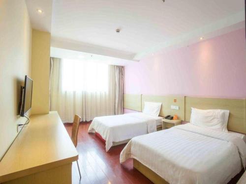 Tahe的住宿－7 Days Inn Beijing Shunyi Development Area Mordern Motor City，酒店客房设有两张床和电视。