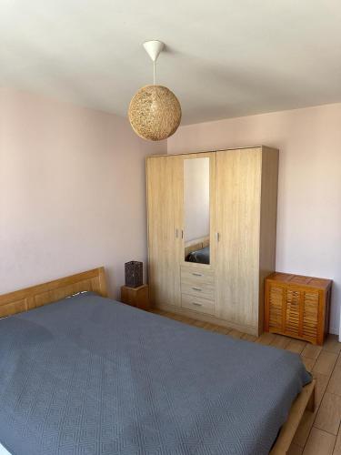 a bedroom with a blue bed and a cabinet at Duplex 10 mn de Paris in Alfortville