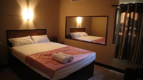 a bedroom with two beds and a large mirror at ห้องพักทิวไม้ in Ban Thung Phai