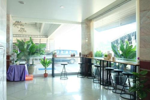 Century Grand Hotel في Bung Kan: غرفة مع بار مع المقاعد والنباتات
