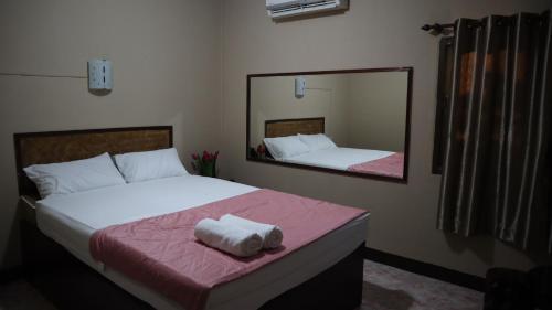 a bedroom with two beds and a mirror at ห้องพักทิวไม้ in Ban Thung Phai
