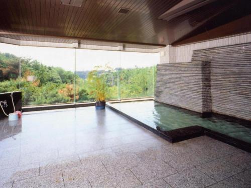 a large room with a pool of water in a building at Tomoyama Kanko Hotel in Azena