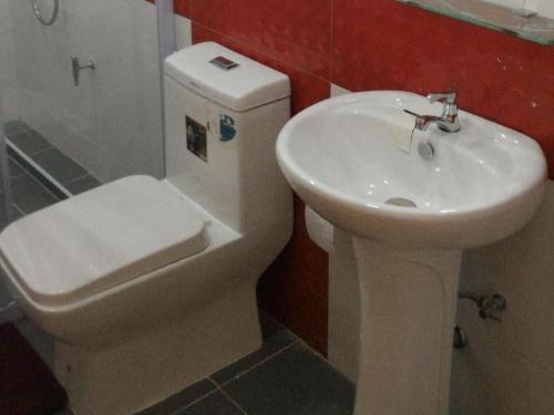 uma casa de banho com um WC branco e um lavatório. em V-House Hotel em Trang