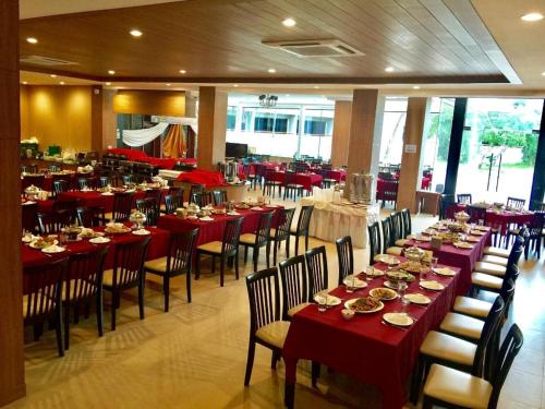uma sala de jantar com mesas e cadeiras com toalha de mesa vermelha em The Impress Nan Hotel em Nan