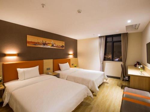 a hotel room with two beds and a window at 7 Days Inn Yingshang Lanxing Building Materials Market in Fuyang