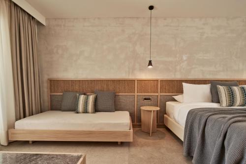 a bedroom with two beds and a couch at Atlantica Marmari Palace in Mastichari