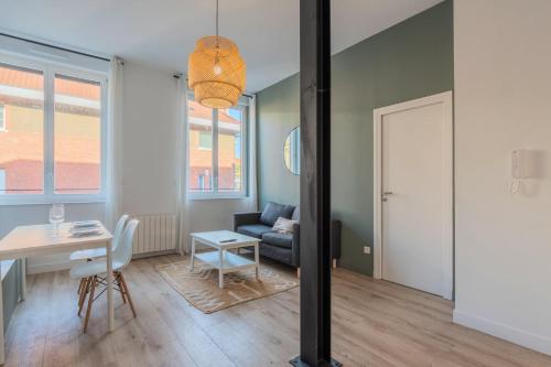 un salon avec une table et un canapé dans l'établissement 1 bedroom apartment in city center with parking, à Tourcoing
