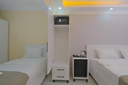 a bedroom with two beds and a small table in it at Lucky Hotel İstanbul in Istanbul