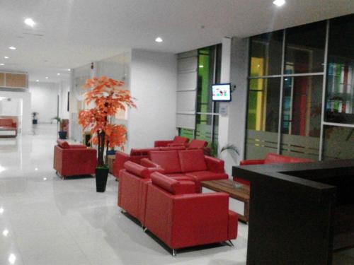 hol z czerwonymi krzesłami i doniczką w obiekcie Le Man Hotel Lampung w mieście Umbulan Tulungmeris