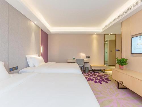 a hotel room with two beds and a flat screen tv at Beijing Lavande Hotel Shunyi Subway Station Branch in Shunyi
