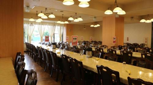 a large room with long tables and chairs at Hotel New Otsuka in Shirako