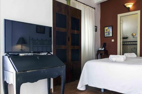 a bedroom with a bed and a piano in it at Hotel Utopía in Benalup Casas Viejas