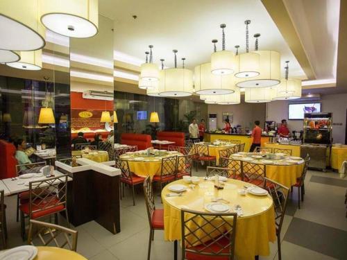 un comedor con mesas y sillas amarillas en Isabela Zen Hotel & Restaurant Corporation, en Santiago