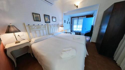 a bedroom with a large white bed and a lamp at Hotel Utopía in Benalup Casas Viejas