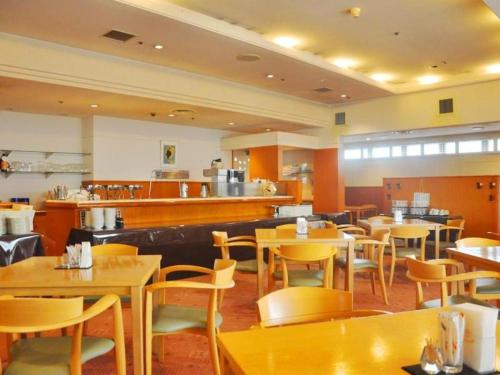 奥州市にあるMizusawa Grand Hotelのテーブルと椅子のあるレストラン、バー