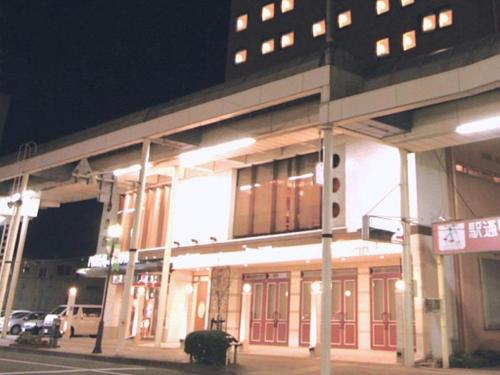 um edifício com portas vermelhas numa rua à noite em Mizusawa Grand Hotel em Oshu