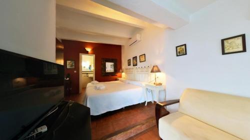 a bedroom with a white bed and a couch at Hotel Utopía in Benalup Casas Viejas