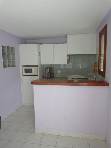 une cuisine avec des armoires blanches et un comptoir dans l'établissement Villa Petra, à Sainte-Maxime