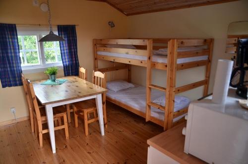 a room with a bunk bed and a table and a dining room at Åbyggeby Landsbygdscenter in Ockelbo