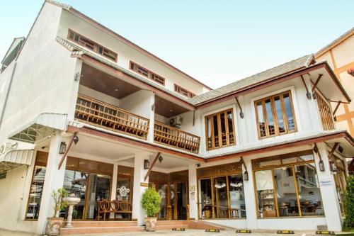 a large white building with a lot of windows at The Indigo House Phrae in Phrae