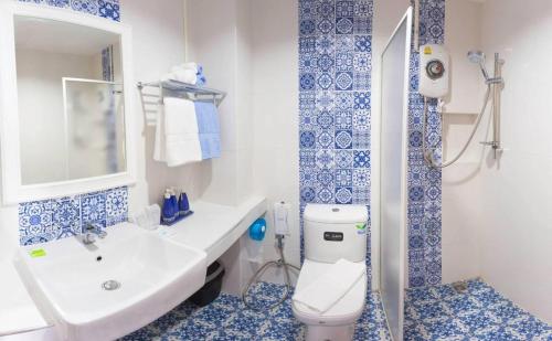 uma casa de banho com um WC, um lavatório e um chuveiro em The Indigo House Phrae em Ban Rong Fong