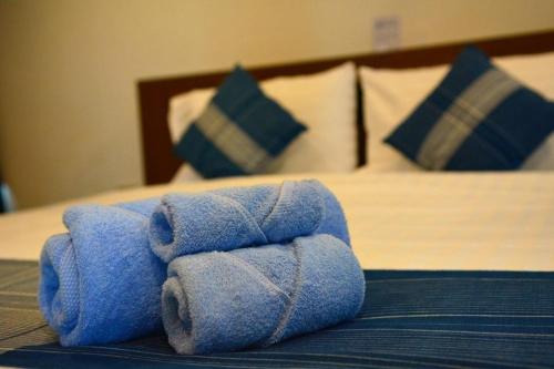uma pilha de toalhas sentadas em cima de uma cama em The Indigo House Phrae em Ban Rong Fong