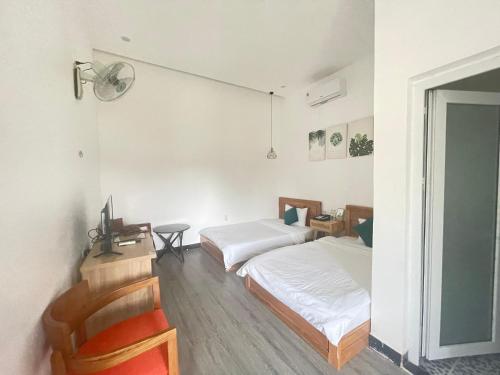 Kon Tum的住宿－D'Villa Hotel - Homestay，一间卧室配有两张床、一张桌子和一把椅子