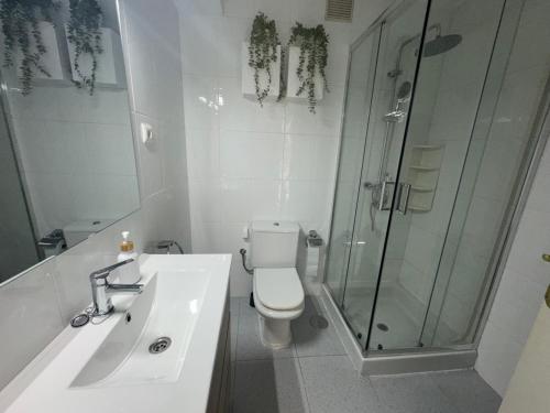 y baño con ducha, aseo y lavamanos. en Apartamento Muchavista Primera Línea de Playa By El Conserje en El Campello