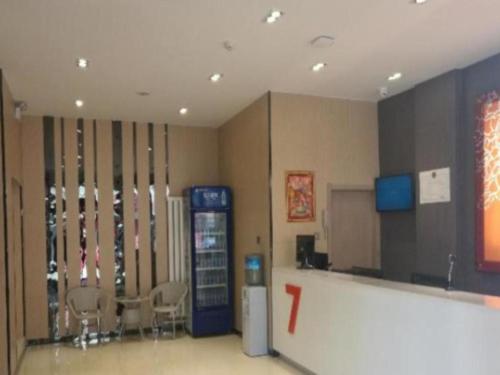 una habitación con una máquina de refrescos y sillas. en 7 Days Premium Hohhot Hailiang Square, en Hohhot