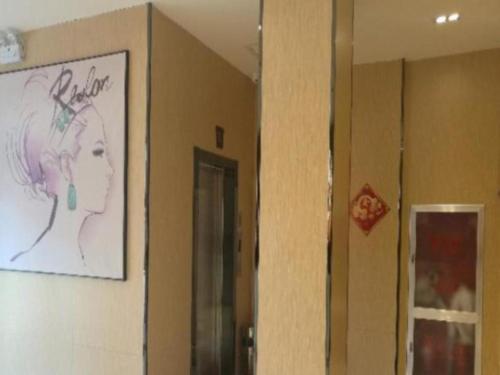un disegno di una donna su un muro in una stanza di 7 Days Premium Hohhot Hailiang Square a Hohhot
