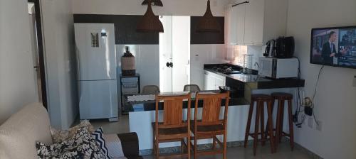 een keuken met een aanrecht en een keuken met een koelkast bij Porto Ville Home - AP 2 quartos in Porto Seguro